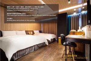 a hotel room with two beds and a desk at Calligraphy Greenway Hotel in Taichung