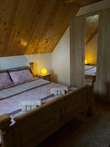 ein Schlafzimmer mit einem großen Bett und einer Holzdecke in der Unterkunft Golden Wood House in Žabljak