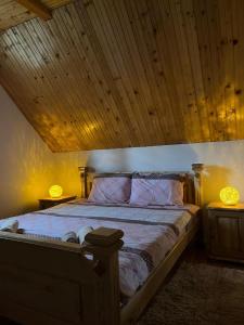 Schlafzimmer mit einem Bett mit Holzdecke in der Unterkunft Golden Wood House in Žabljak