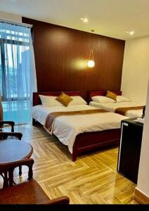 Habitación de hotel con 2 camas y mesa en Khách Sạn Phụng Vy, en Ap Rạch Soi
