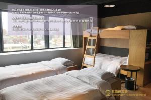two bunk beds in a room with a window at Calligraphy Greenway Hotel in Taichung