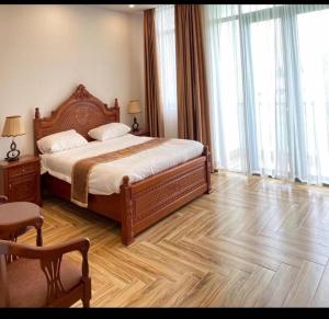 1 dormitorio con 1 cama grande y suelo de madera en Khách Sạn Phụng Vy, en Ap Rạch Soi
