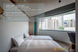 two beds in a room with a large window at Calligraphy Greenway Hotel in Taichung