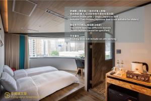 a bed in a room with a large window at Calligraphy Greenway Hotel in Taichung