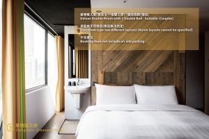 a bedroom with a white bed and a sink at Calligraphy Greenway Hotel in Taichung