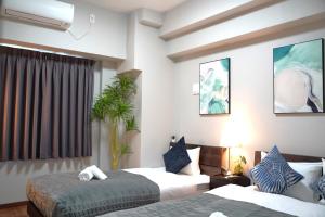 ein Hotelzimmer mit 2 Betten und einem Fenster in der Unterkunft Kuromon Royal Niponbashi in Osaka