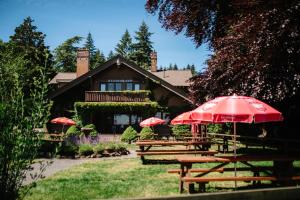 a group of picnic tables with umbrellas in front of a house at Beach Acres Resort in Parksville