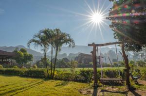 a view of a garden with the sun in the sky at The Nest House in Pai