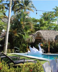 una piscina con dos cisnes en un complejo en VillasMana Complex PlayaBonita LasTerrenas Samana NearBeach WiFi en Las Terrenas