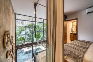 a bedroom with a bed and a large window at Unique 1BR Swim up Cenote, and Gym in Tulum +32 photos