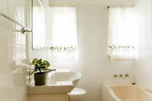 ein Badezimmer mit einer Badewanne, einem WC und einem Waschbecken in der Unterkunft King Cottage in Windsor