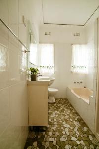 a bathroom with a sink and a tub and a toilet at King Cottage in Windsor
