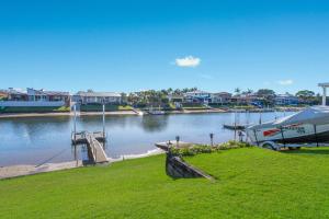 a boat is parked at a dock next to a body of water at 29A Ballina Crescent Port Macquarie in Port Macquarie