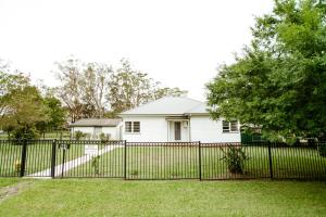 a white house with a black fence at King Cottage in Windsor