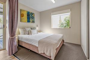 Un dormitorio con una cama grande y una ventana en BIG4 Tasman Holiday Parks - Tathra Beach en Tathra