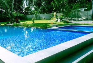 uma piscina com água azul num quintal em The Lavana Camp Coco Batangas by RedDoorz em Alitagtag
