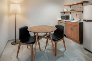La cuisine est équipée d'une table, de deux chaises et d'un réfrigérateur. dans l'établissement Fairfield by Marriott Inn & Suites Rome NY, à Rome