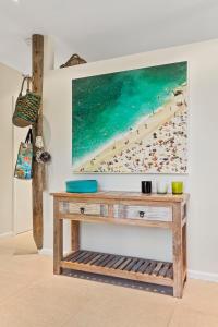 Una pintura de una playa con gente en la arena. en Surfside at Lonnie, en Point Lonsdale