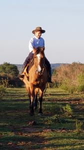 a man riding a horse in a field at Cabaña en el campo in Tacuarembó