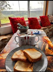 a table with two plates of toast and two cups of coffee at Cabaña en el campo in Tacuarembó