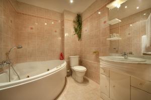 uma casa de banho com uma banheira, um WC e um lavatório. em Hotel Henrietta em Praga