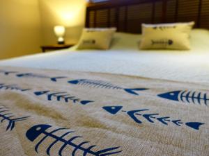 Una cama con una manta azul y blanca. en Coconut Beach House en Cape Tribulation