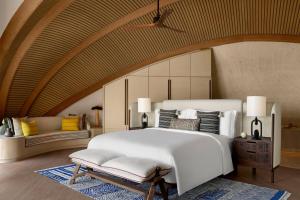1 dormitorio con 1 cama blanca grande y 1 sofá en Nujuma, a Ritz-Carlton Reserve, en Ḩanak