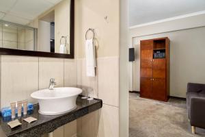 a bathroom with a sink and a mirror at Protea Hotel by Marriott Pretoria Hatfield in Pretoria