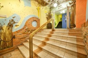 a staircase in a building with a mural on the wall at Hotel Henrietta in Prague