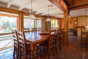 een eetkamer met een houten tafel en stoelen bij Warrina - Overlooks Ovens River and five minute walk into town in Bright