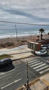 una calle con coches estacionados junto a una playa en Edificio oceanic la serena, en La Serena