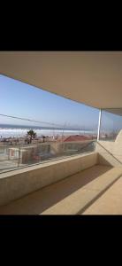 vistas a la playa desde un edificio con ventana en Edificio oceanic la serena, en La Serena