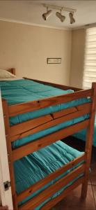 1 dormitorio con cama de madera con sábanas verdes en Edificio oceanic la serena, en La Serena
