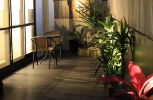 Cette chambre comprend une table, des chaises et des plantes. dans l'établissement Cachette -SEVEN Hotels and Resorts-, à Uruma