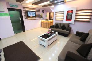 a living room with two couches and a table at Al Huda Hotel in Malacca