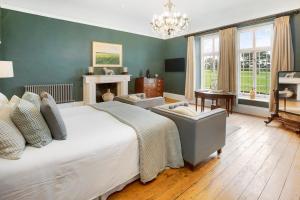 a bedroom with a large bed and a chandelier at Colleton Hall in Rackenford