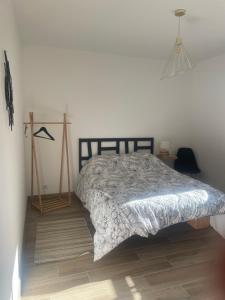 a bedroom with a bed with a gray comforter at Gîte cévenol pleine nature tout confort in Soudorgues