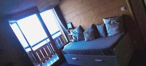 Cama con almohadas en habitación con balcón en Prapoutel en Prapoutel