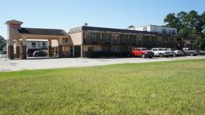 a building with cars parked in a parking lot at Executive Inn & Suites in Orange