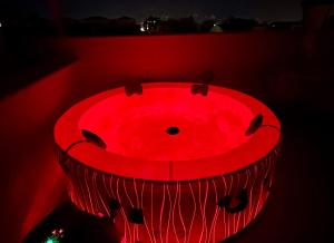 uma banheira vermelha com uma luz vermelha no escuro em Guest house palermo em Palermo