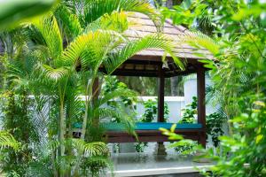 un cenador en un jardín con palmeras en Dani Vila, 2BR, Pool, enclosed kitchen and living area at Buleleng, North Bali, en Gretek