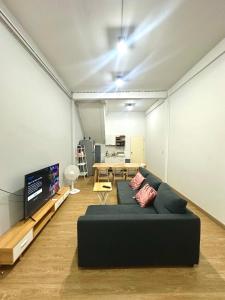 Bee House 172 only 300m to BTS Talat Phlu في بانكوك: غرفة معيشة مع أريكة وتلفزيون بشاشة مسطحة