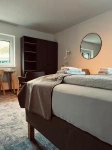 - une chambre avec un lit et un miroir dans l'établissement Pension Auer, à Liebenfels