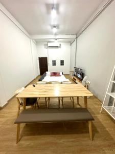 Zimmer mit einem Holztisch und einem Bett in der Unterkunft Bee House 172 only 300m to BTS Talat Phlu in Bangkok