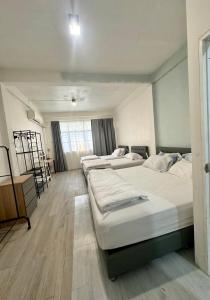 a room with four beds in a room with a window at Bee House 172 only 300m to BTS Talat Phlu in Bangkok