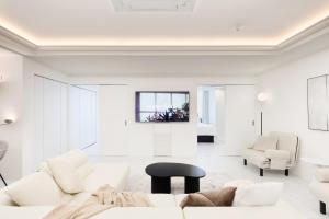 a living room with a white couch and a chair at CITY HOTEL Namba Residence 3 in Osaka