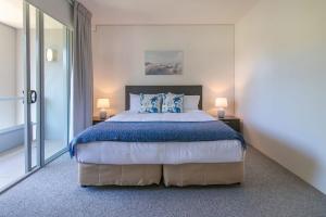 um quarto com uma cama grande e 2 candeeiros em 325 Harbour Lights with Garden View em Cairns