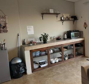 a kitchen with a counter with dishes and a microwave at Breathtaking Midlands stay at THE PROTEA CHALET 5kms from N3 in Hilton