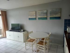 cocina con mesa, sillas y pinturas en la pared en Studio Residentie Astrid, en Bredene