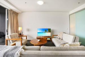 a living room with a couch and a table at 903 Harbour Lights with Ocean Views in Cairns